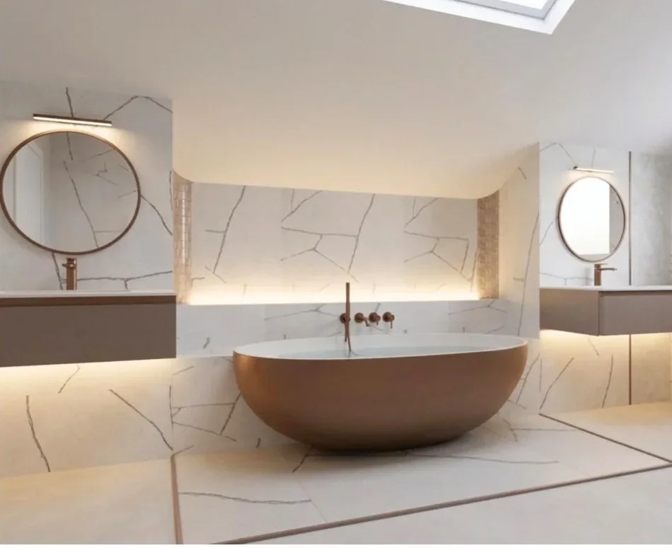 DDL design visual of the Stanmore master en-suite: white marble-look walls with bold dark veining around a copper freestanding bath, a plain pale floor with a veined marble-look panel set into it beneath the bath and edged in copper trim, round mirrors over two wall-hung vanities and a lit recess behind the bath